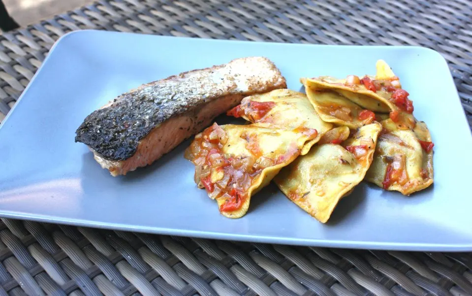 Lachssteak mit gefüllten Nudeln auf dem Teller angerichtet