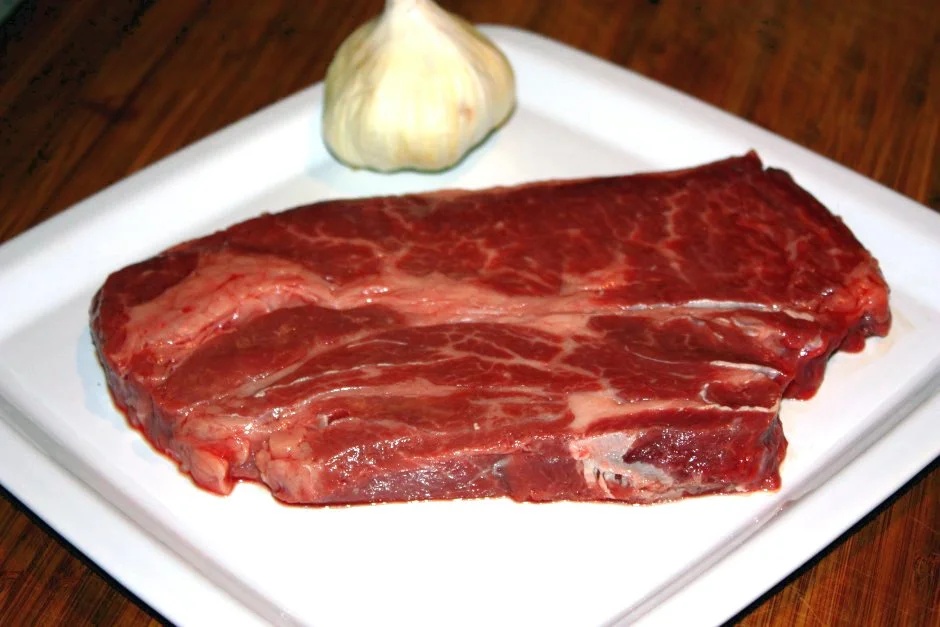 Rohes Nackensteak vom Rind auf dem Teller vor dem Braten