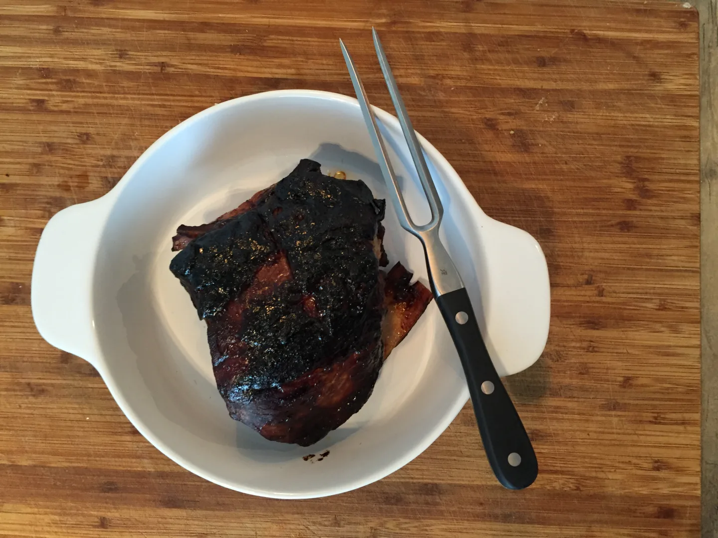 Gegartes Fleischstueck mit dunkler BBQ-Kruste in weisser Schale
