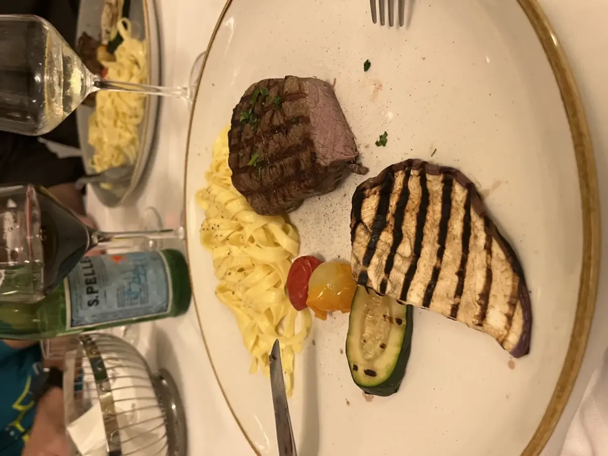 Filet Mignon mit Tagliatelle und gegrillter Aubergine auf weißem Teller im Restaurant