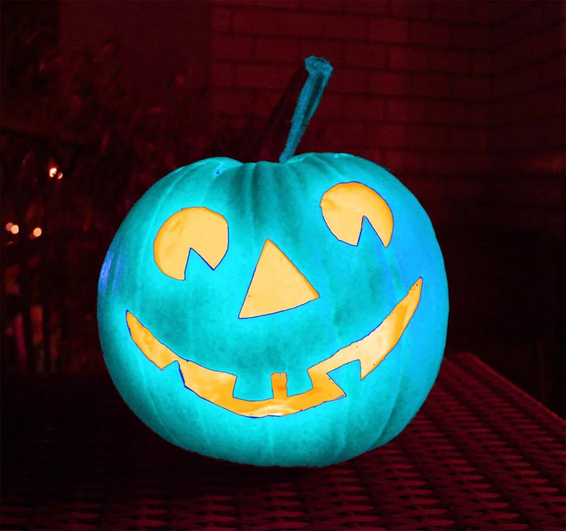 Halloween-Kürbis bei Nacht mit Kerze beleuchtet in blauem Licht