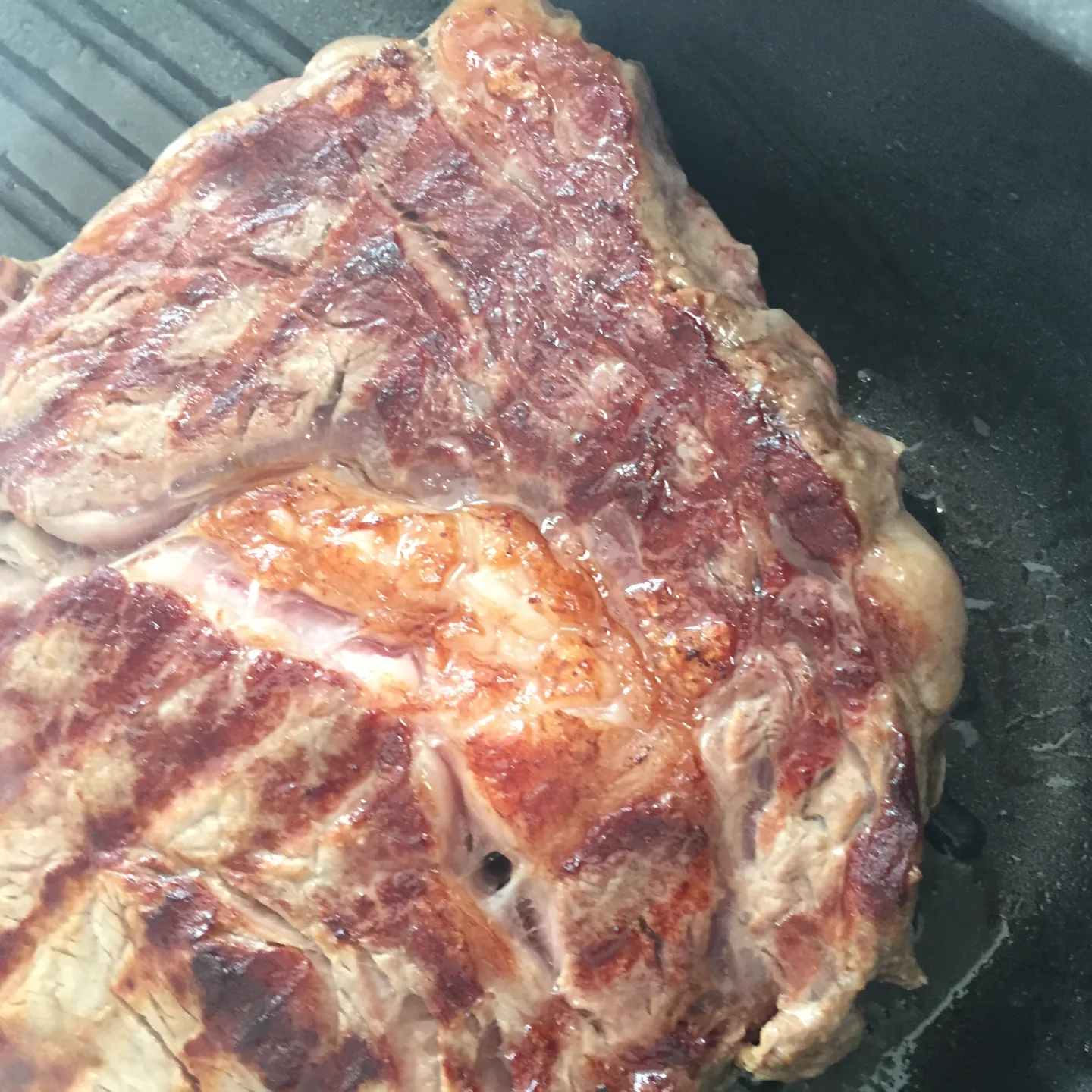 Makro-Aufnahme einer perfekt gebratenen Steak-Kruste als Metapher für technische Präzision