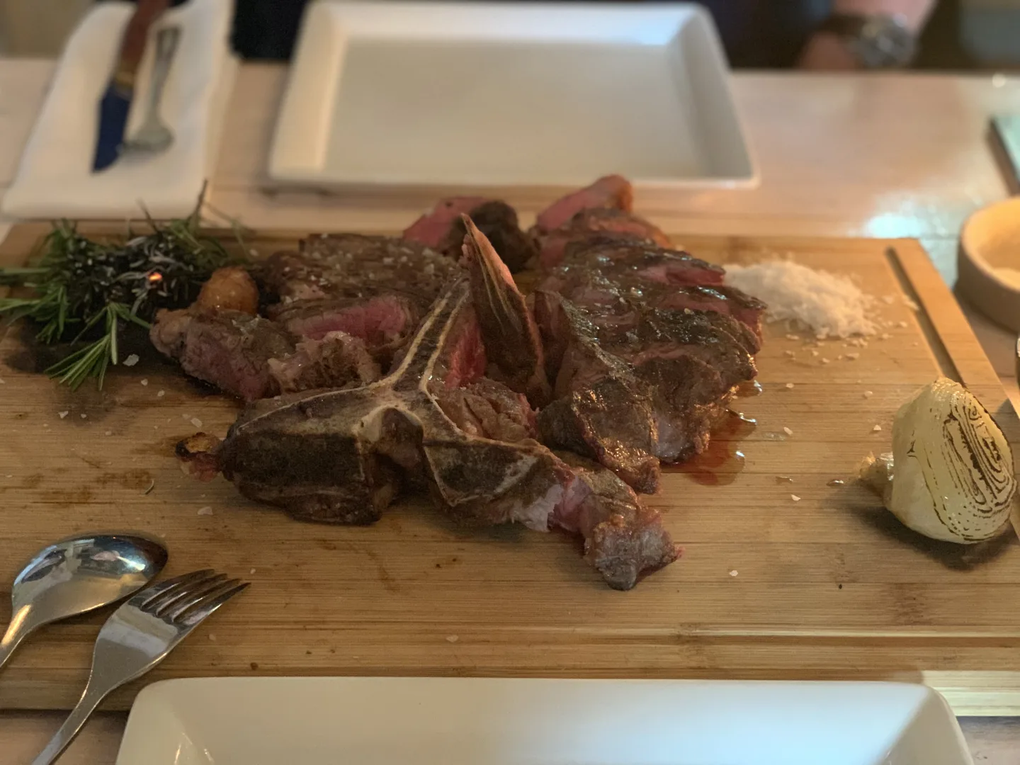 Porterhouse aufgeschnitten mit Rosmarin auf Holzbrett