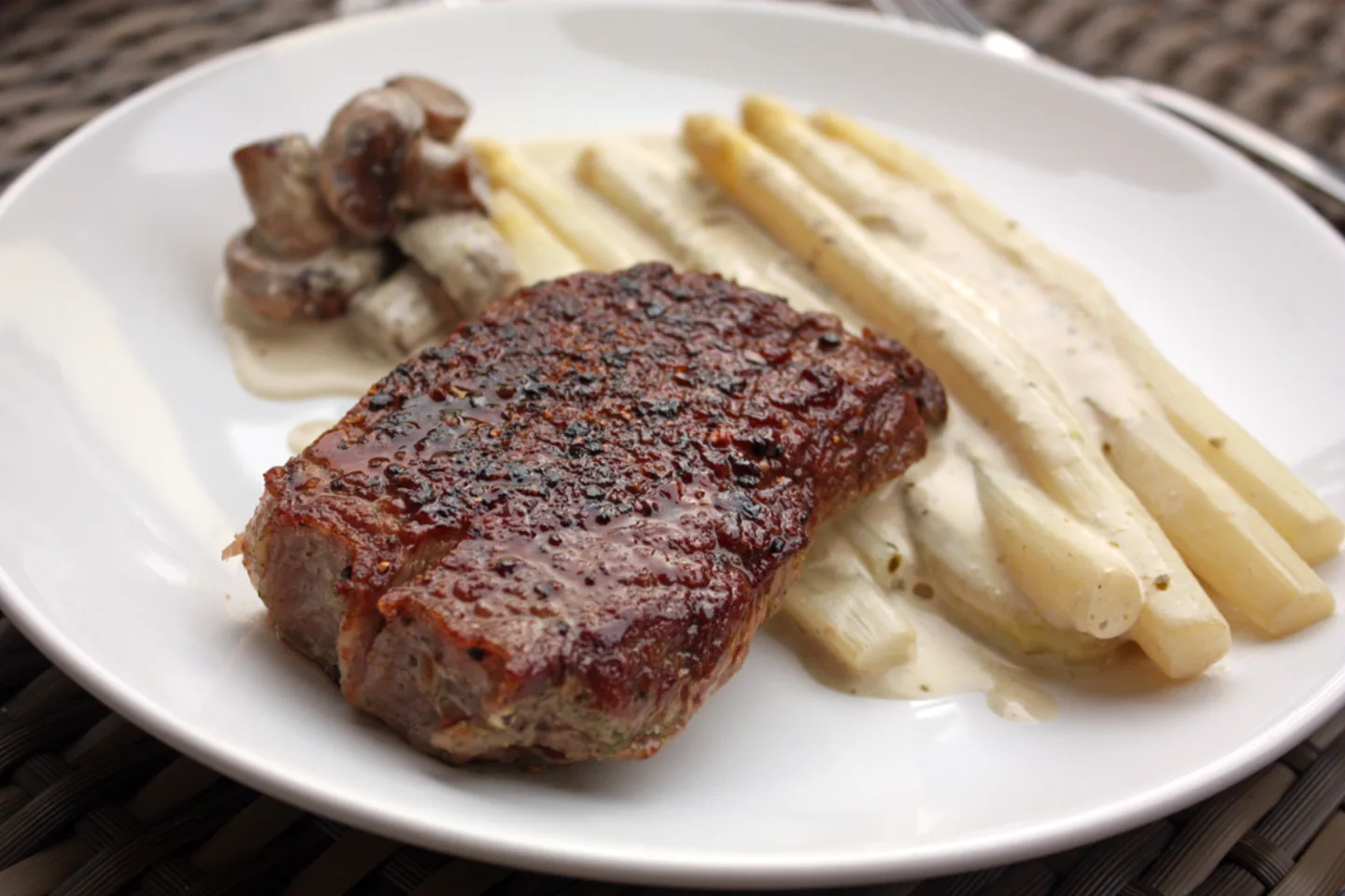 Gebratenes Rumpsteak mit gruenen Spargel und Champignons