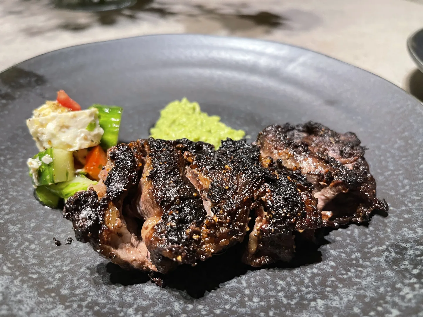 Gegrilltes Steak mit dunkler Kruste und Guacamole auf Teller